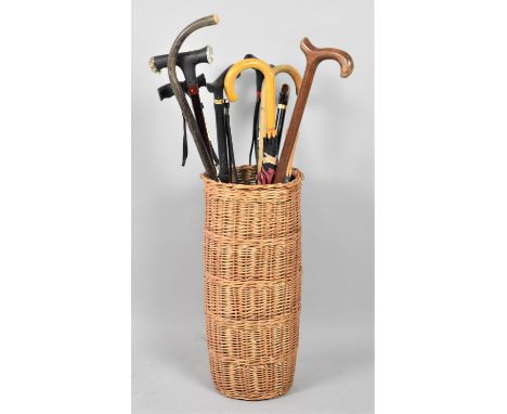 A Cylindrical Wicker Stick Stand Containing Modern Walking Sticks and Umbrellas 