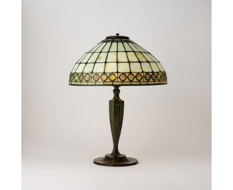 Circa 1915The domed shade with three central rows of large geometric segments in mottled opalescent and amber colored glass, 