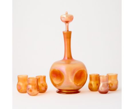 Circa 1902Comprising a decanter and stopper and six cordial glasses, each in translucent amber colored glass, with a dimpled 