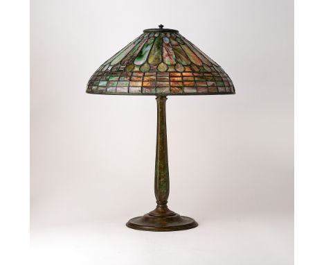 Circa 1915The conical shade decorated with stylized feather motifs and a geometric border, in mottled green, amethyst and opa