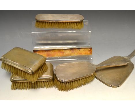 Silver- an Art Deco four piece dressing tableset comprising, hand mirror, hairbrush, clothes brush, comb, engraved with a sun