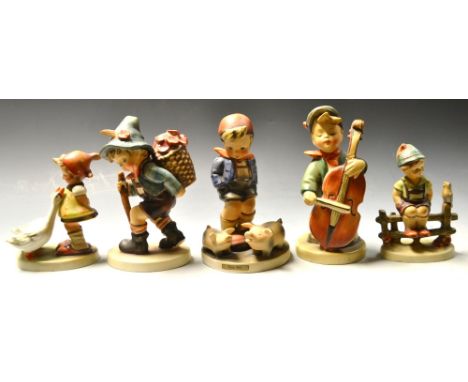 A collection of five Goebel Hummel figures, including Farm Boy, Girl and Two Geese, Hiking Boy, Violin Player and Boy on a Fe