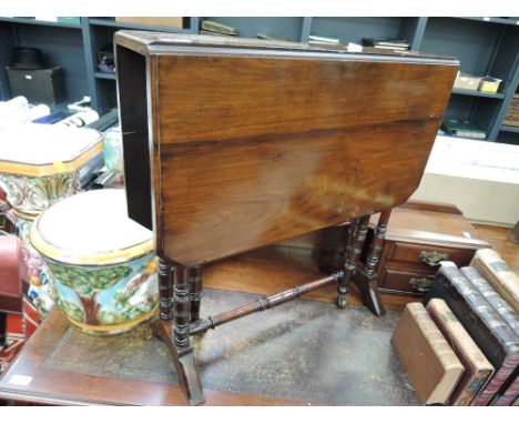 An early 20th century mahogany sutherland table having canted drop flaps and ring turned gate legs