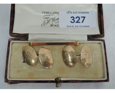 A pair of yellow metal oval cufflinks stamped 9ct having chain connectors and monogrammed AW, and a yellow metal tie bar stam