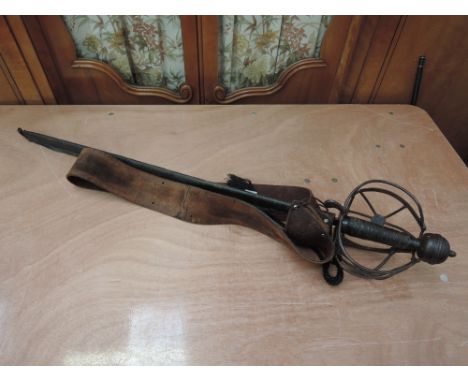 A coppy of a Scottish broadsword with basket hilt and leather belt and scabbard, blade length 31'