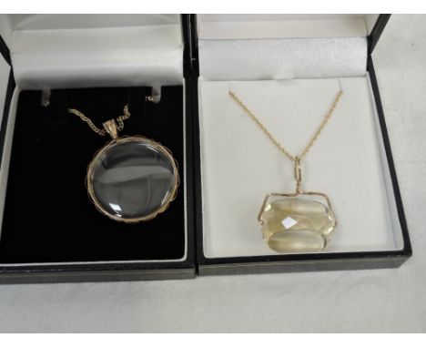 A double sided locket in a yellow metal mount on a yellow metal chain stamped 375, and a pale citrine style facetted stone in