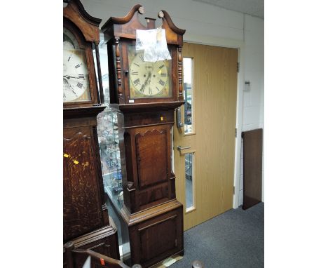 An early 19th century mahogany and oak longcase clock having swan neck pillar hood containing square painted face and 8 day m