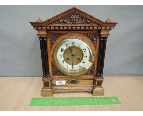 A late Victorian/Edwardian golden oak case mantel clock having architectural case with pillar and carved decoration containin
