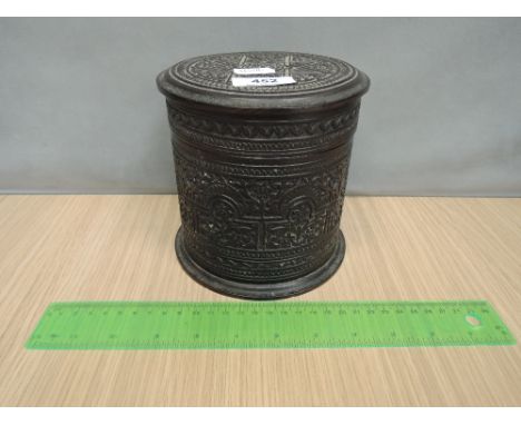 A late 19th century hardwood Eastern caddy of cylindrical form, having extensive carved decoration