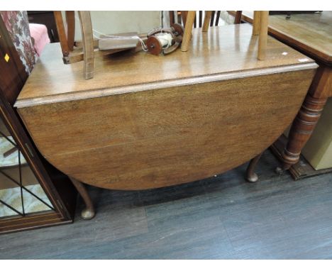An early/mid 20th century oak dining table having drop leaf top on pad foot gate legs