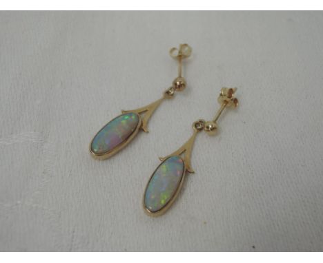 A pair of 9ct gold stud earrings having opal drops in collared mounts