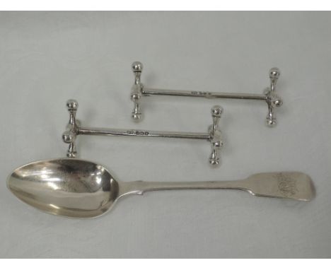 A pair of silver knife rests of traditional design, Sheffield 1919, Mappin & Webb, and a Victorian HM silver dessert spoon