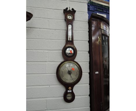 An early 19th century mahogany wheel barometer having swan neck with humidity and thermometer scale, with level and silvered 