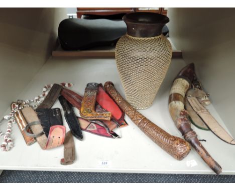 A selection of ethnic leather sheathes, a treen webbed vase, ethnic clubs etc