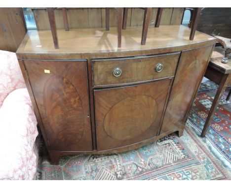 An early 20th century mahogany sideboard by Maple & Co in the Regency style having bow front with central drawer and cupboard