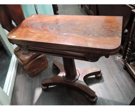 An early 19th century William IV mahogany card table having swivel top on chamfered column and platform base