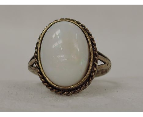 A lady's dress ring having an oval opal in a collared mount with gold wire decoration to 9ct gold loop