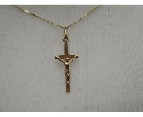 A 9ct gold crucifix of traditional form on a 9ct gold chain