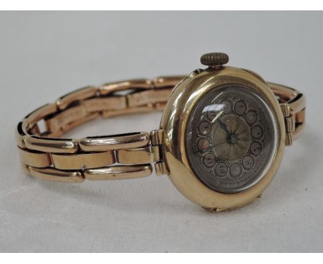 A lady's vintage 9ct rose gold wrist watch having Arabic numeral dial to engine turned face on a rose metal stretch strap sta