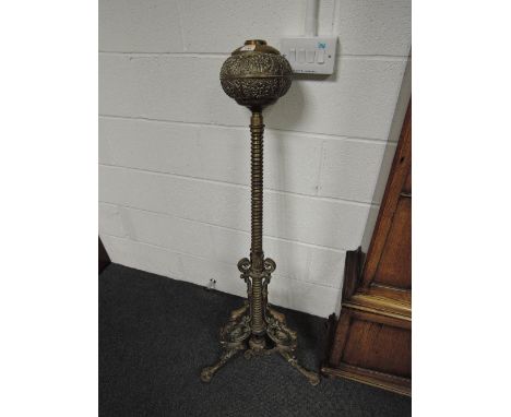 A late Victorian brass oil lamp stand having embossed reservoir and trefoil scroll base