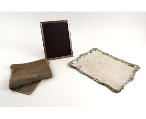 A SPANISH DRESSING TABLE TRAY AND A SILVER MOUNTED PHOTOGRAPH FRAME (2)The shaped rectangular tray with scrolled decoration t