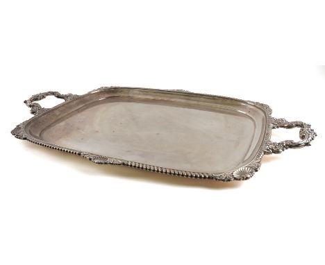 A SILVER TWIN HANDLED TRAYOf curved rectangular form, having a gadrooned rim with scallop and scroll motifs at intervals, len