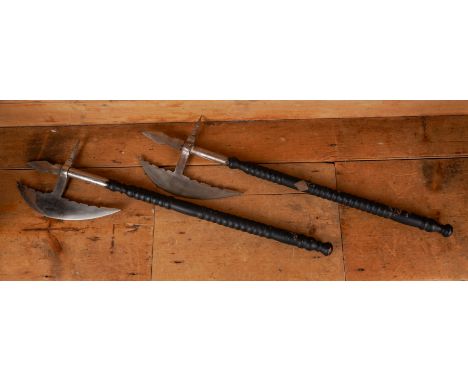 A PAIR OF VICTORIAN ORNAMENTAL POLISHED STEEL AXES (2)Late 19th Century 
With ebonised shafts, the axe heads with stippled de