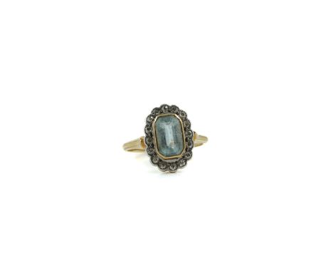 A GOLD, AQUAMARINE AND DIAMOND CLUSTER RINGMounted with the cut cornered rectangular step cut aquamarine, within a surround o