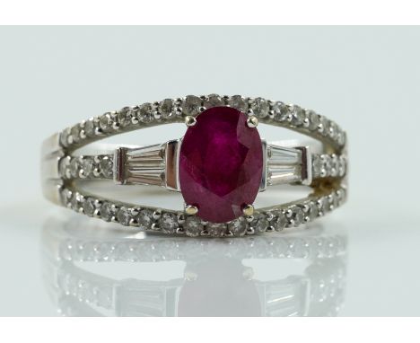 A WHITE GOLD, RUBY AND DIAMOND RINGClaw set with the oval cut ruby at the centre between tapered baguette diamond two stone s