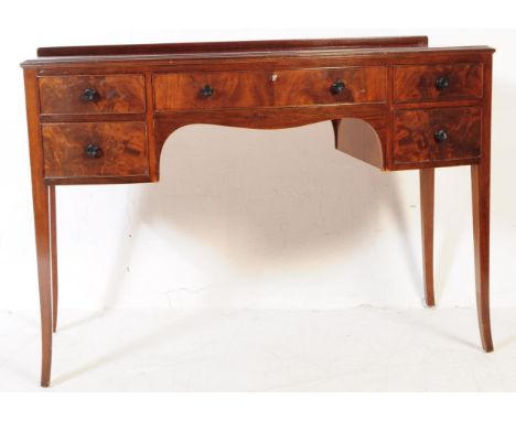 An Edwardian mahogany bow front writing table desk. Raised on square tapering legs with a series of short drawers flanking ce