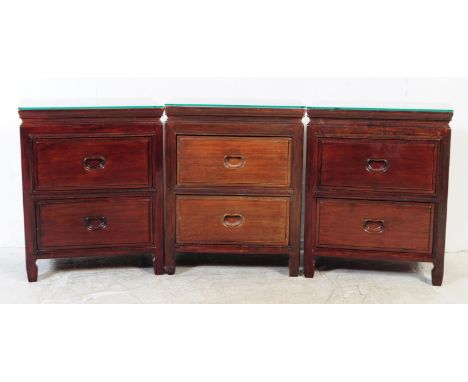 A pair of vintage 20th century Chinese hardwood bedside table / cabinets. Rectangular form with a bank of two drawers, bracke