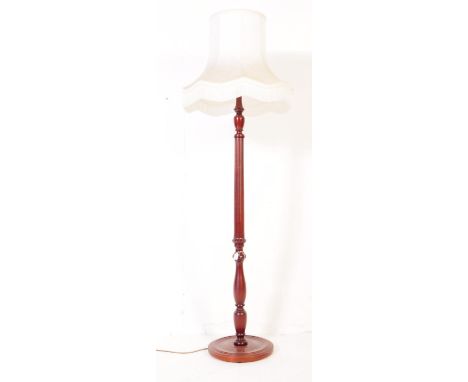 A twentieth century Victorian style mahogany standard lamp. Turned and carved vertical column with circular turned and dished