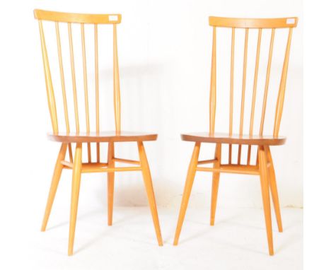 Ercol Furniture - A matching pair of retro 20th century beech kitchen chairs by Ercol. With spindle back design raised on rou