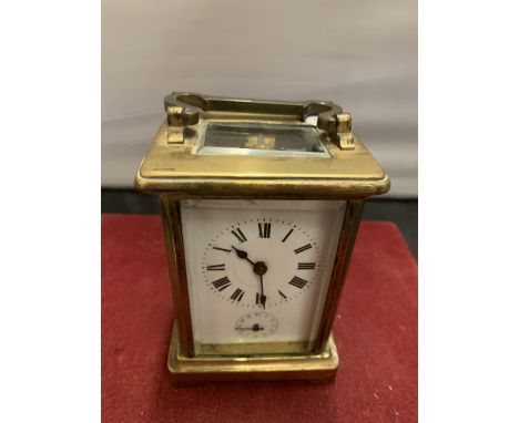 A FRENCH BRASS CARRIAGE CLOCK WITH WHITE ENAMEL DIAL AND SECONDHAND FEATURE (KEY) - 11CM HIGH 