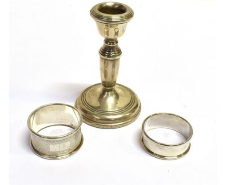 SILVER CANDLE STICK &amp; NAPKIN RINGS A dainty sterling silver single candlestick, stands approx 10cm tall, together with tw