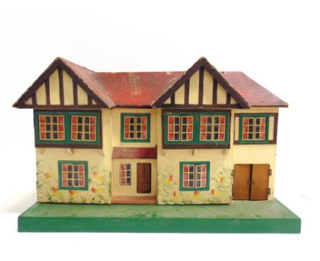 A TRI-ANG DOLL'S HOUSE  the mock-Tudor, gabled, side-hinged front elevation opening to reveal an interior arrangement of four