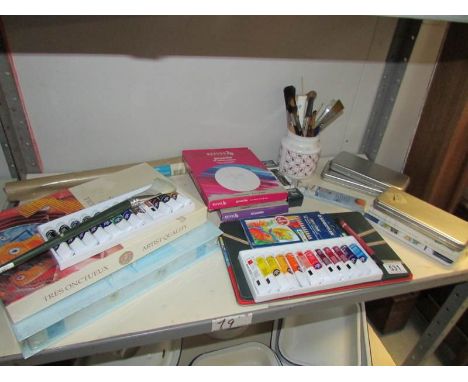 A shelf of art materials including paints, brushes etc