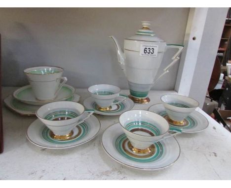 A coffee pot with 4 matching cups and saucers together with a trio