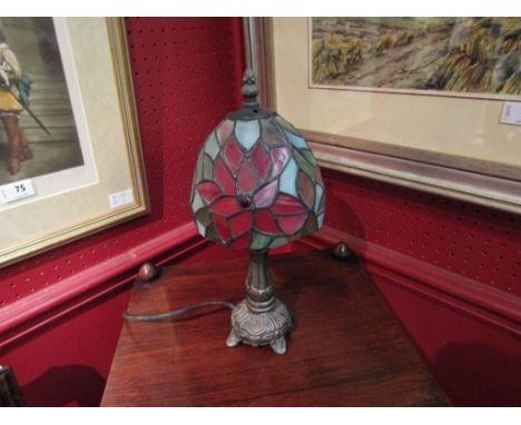 A metal based table lamp with Tiffany style shade