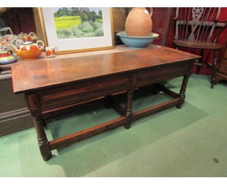 A 17th Century style oak window bench the hinged and cleated end seat over six cannon barrel turned legs joined by stretchers
