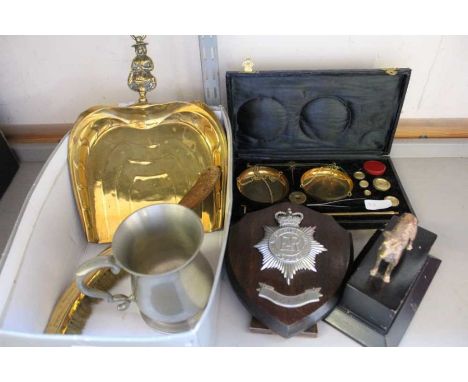 A box containing cast metal dog ornament on plinth, cased balance scales, brass crumb scoop and brush, pewter tankard, and We