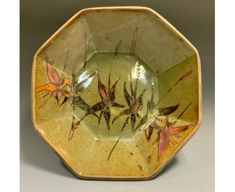 In the style of Dan Arbied (1928-2010)  an octagonal studio pottery table bowl, painted with stylized flowers, mottled glaze,