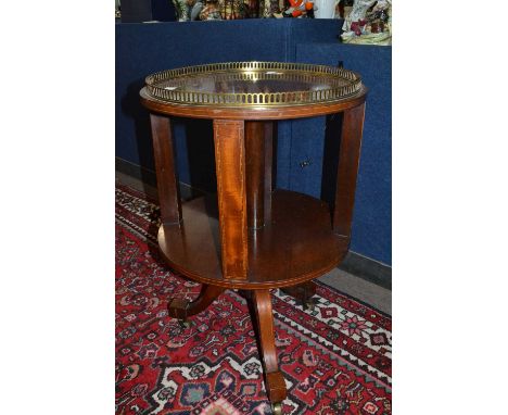 An Edwardian mahogany circular bookcase with brass galleried top, turned column and tripod base with block formed feet with c