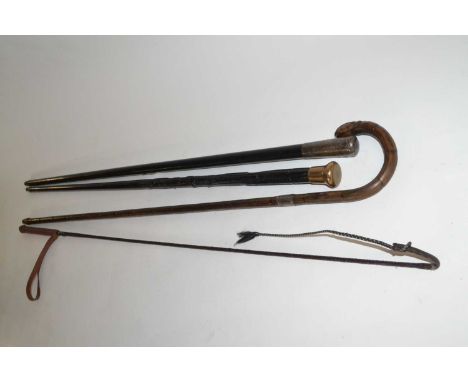 A group of three walking canes, one with a white metal decorated top, further wooden one with silver collar together with a w