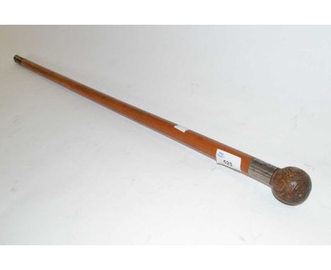 An antique walking stick with ball finial, carved with foliate and geometric designs with a metal collar engraved with initia
