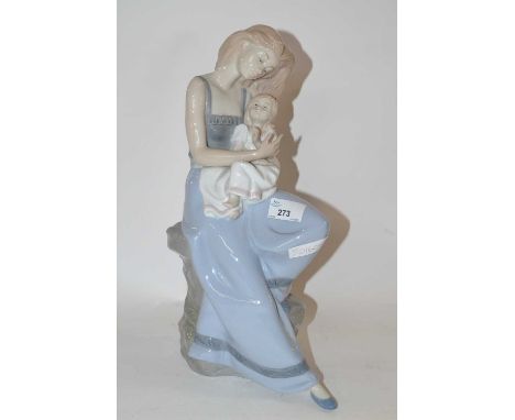 A large Nao porcelain figure of a lady holding a child seated on a rock work base, 40cm high
