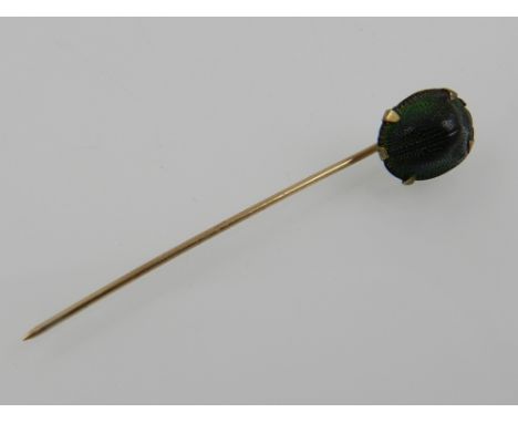 A yellow metal and painted metal tie pin shaped as a scarab beetle. 