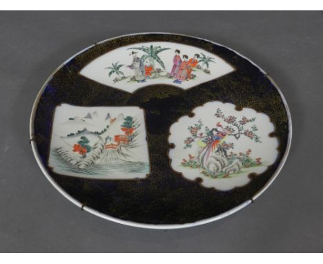 A Chinese hard paste porcelain display charges, decorated with panels of landscape scene on a black and gilt scroll base, bea