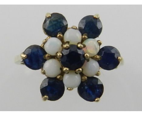 A 9 carat yellow gold, sapphire, and opal set floral cluster ring, set seven sapphires and six opals, the shank stamped 375. 