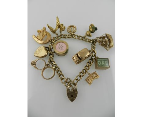 A 9 carat yellow gold curb link bracelet, hung various 9 carat yellow gold charms including a poodle, a ship, a car, a folded